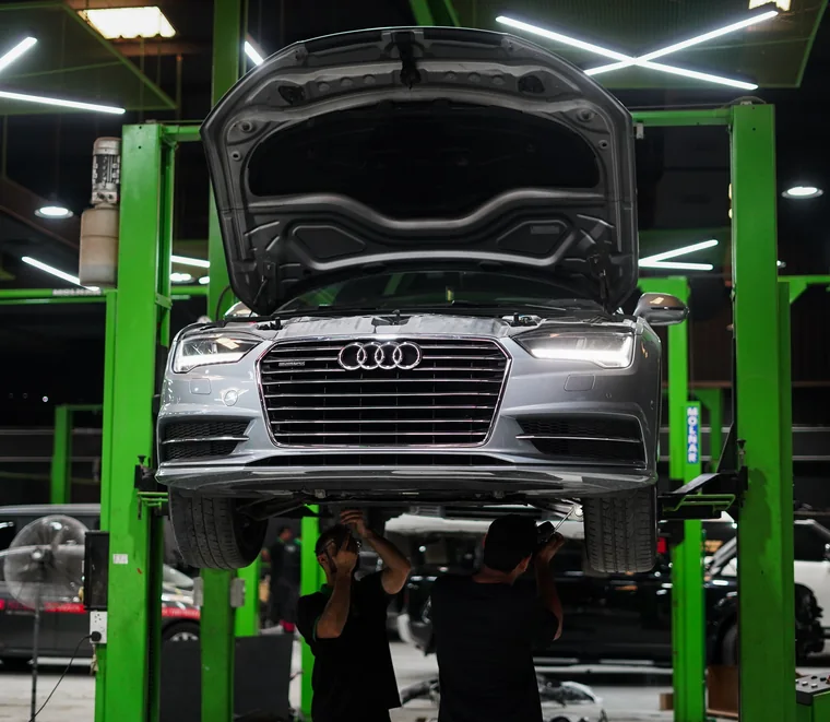 Audi A6 on a two-post lift for undercarriage service in Abu Dhabi