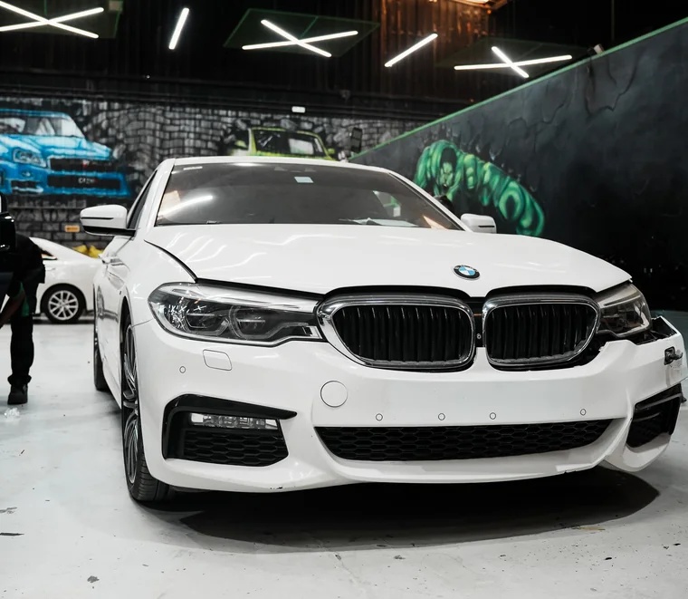 White BMW 5 Series M Sport in a service bay at System X Car Care in Al Quoz, Dubai, Abu Dhabi.
